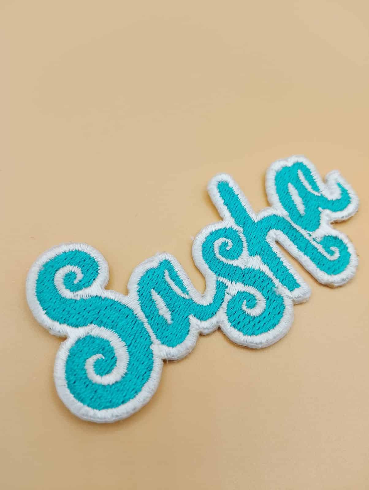 sasha emb patch in cyan embroidery viscose thread extreme die cut 2 inches cut out with white embroidered outline edge for iron on placement